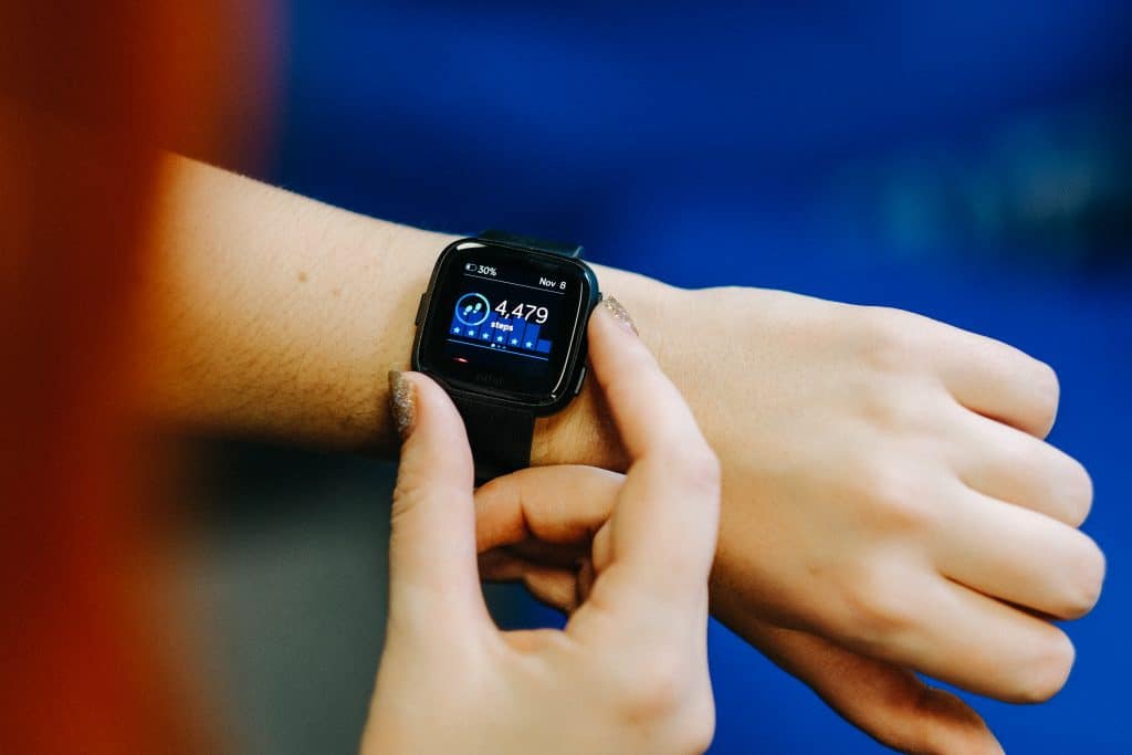 woman checking her fitness tracker watch to see how many calories she burned. 