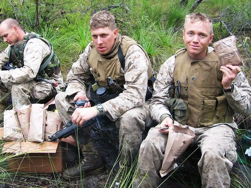 Soldiers sitting down and holding MREs