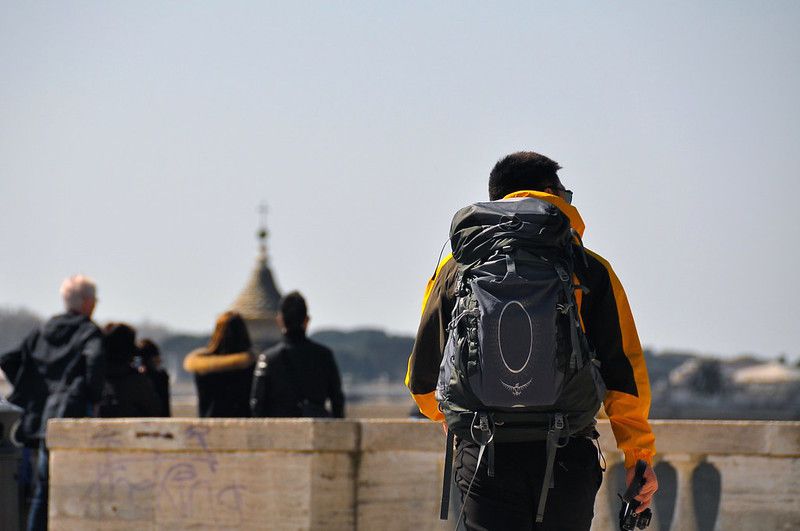 sightseer walking while carrying a rucksack