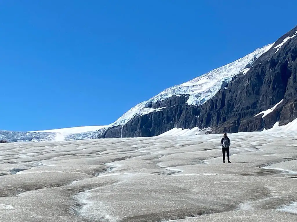 Adam walking on the frozen water from the glacier while wearing the GORUCK Ballistic Trainers